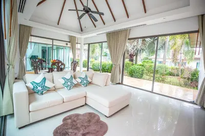 a living room with a white couch and large windows at Phuket Boutique Pool Villa-79 in Rawai Beach