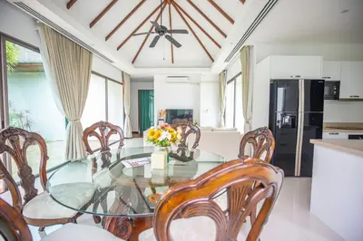 a dining room with a glass table and chairs at Phuket Boutique Pool Villa-79 in Rawai Beach