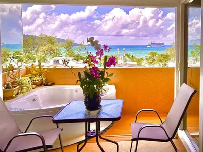a bathroom with a tub and a table with flowers on it at Patong Tower Holiday Rentals in Patong Beach