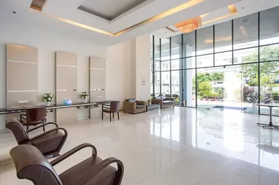 a large lobby with chairs and tables and windows at Patong Tower Holiday Rentals in Patong Beach