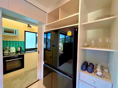 a kitchen with a black refrigerator and a stove at Patong Tower Holiday Rentals in Patong Beach