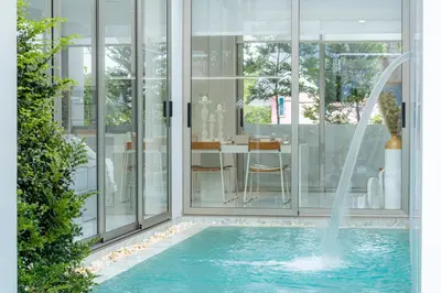 a swimming pool with a fountain in a house at Exquisite Pool Residence A19: Aesthetics and Luxury Combined in Bang Tao Beach