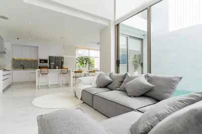 a living room with a couch and a kitchen at Exquisite Pool Residence A19: Aesthetics and Luxury Combined in Bang Tao Beach