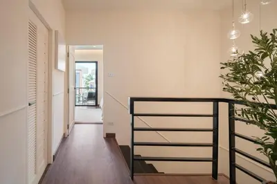 a hallway with a black staircase in a house at Chao Wilai Residence I Naiyang Beach I HKT Airport in Nai Yang Beach