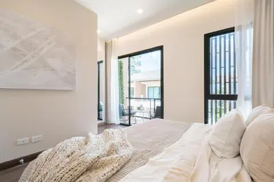 a bedroom with a bed and a large window at Chao Wilai Residence I Naiyang Beach I HKT Airport in Nai Yang Beach