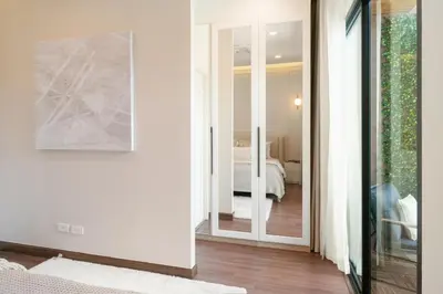 a room with a hallway with a mirror and a bedroom at Chao Wilai Residence I Naiyang Beach I HKT Airport in Nai Yang Beach