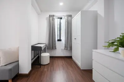 a white room with a desk and a chair at Chao Wilai Residence I Naiyang Beach I HKT Airport in Nai Yang Beach