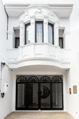 a white house with a black gate at The Elements Boutique House in Phuket Town