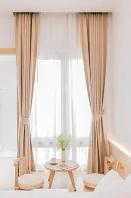 a bedroom with a window with a table and chairs at The Elements Boutique House in Phuket Town