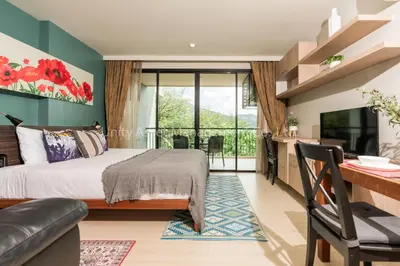 a bedroom with a bed and a desk and a television at The Unity and The Bliss Patong Residence in Patong Beach