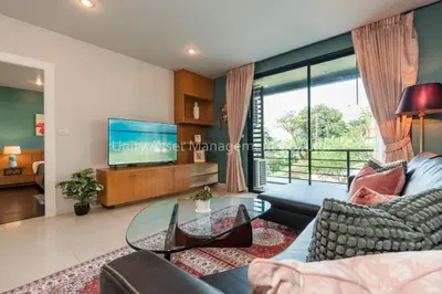 a living room with a couch and a tv at The Unity and The Bliss Patong Residence in Patong Beach