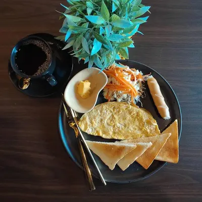 a plate of food with eggs and a plate of food at Black Panther Hostel in Phuket Town