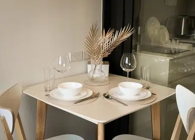 a table with plates and wine glasses on it at Skypark Laguna Rooftop Pool Apartment near Bang Tao Beach in Bang Tao Beach