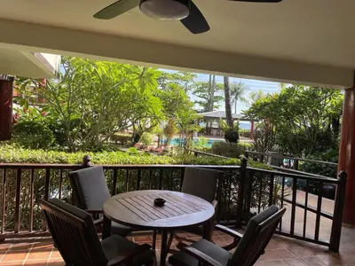 a patio with a table and chairs on a balcony at Peaceful retreat at Kalim Bay - pool bar garden in Patong Beach