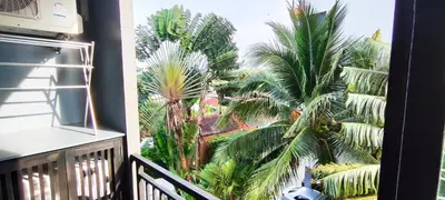 a view of palm trees from a balcony at Relife SPB in Phuket Town
