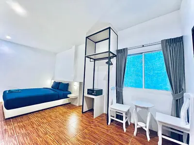 a bedroom with a blue bed and a table and chairs at 88 House Patong in Patong Beach