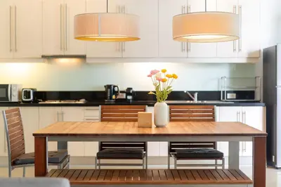 a kitchen with a wooden table with a vase of flowers at Tropical Garden Villa - Oxygen Bangtao Beach in Bang Tao Beach
