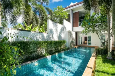 a swimming pool in the backyard of a house with trees at Tropical Garden Villa - Oxygen Bangtao Beach in Bang Tao Beach