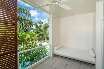 a balcony with a bench and palm trees at Tropical Garden Villa - Oxygen Bangtao Beach in Bang Tao Beach