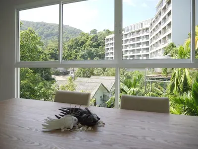 a bird toy sitting on a table in front of a window at Karon beach apartment & sea view pool in Karon Beach