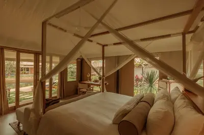 a bedroom with a large bed and a large window at Twinpalms Tented Camp Phuket in Bang Tao Beach