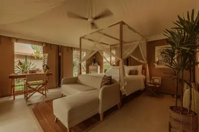 a bedroom with a canopy bed and a couch at Twinpalms Tented Camp Phuket in Bang Tao Beach
