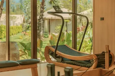 a rocking chair in a room with a window at Twinpalms Tented Camp Phuket in Bang Tao Beach