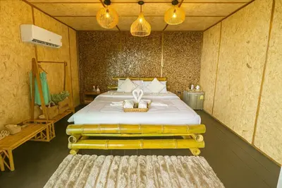 a bedroom with a bed with a basket on it at Greenheart Garden View Camp Phuket in Kata Beach
