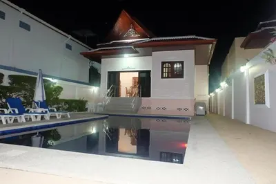 a villa with a swimming pool at night at Majestic Villas Phuket in Rawai Beach