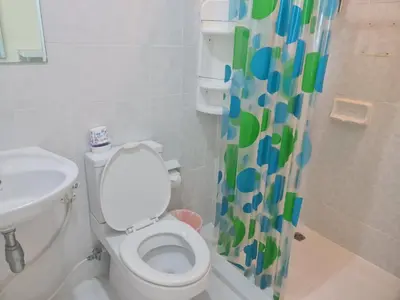 a bathroom with a toilet and a sink and a shower curtain at At Laguna at Zcape Condo in Bang Tao Beach