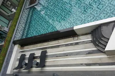 a swimming pool with a sign on the side of a building at At Laguna at Zcape Condo in Bang Tao Beach