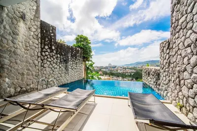 a patio with two chairs and a swimming pool at Patong Villa1\u4e09\u5367\u6cf3\u6c60\u522b\u5885\u4e24\u4e2a\u6d77\u666f\u623f \u8fd1\u73ed\u8d5e\u6c5f\u897f\u51b7\u6d77\u6ee9\u4e2d\u6587\u7ba1\u5bb6 in Patong Beach