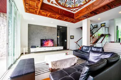 a living room with a couch and a table at Patong Villa1\u4e09\u5367\u6cf3\u6c60\u522b\u5885\u4e24\u4e2a\u6d77\u666f\u623f \u8fd1\u73ed\u8d5e\u6c5f\u897f\u51b7\u6d77\u6ee9\u4e2d\u6587\u7ba1\u5bb6 in Patong Beach