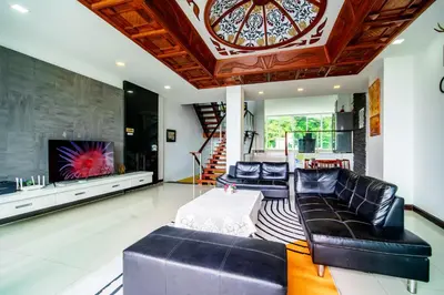 a living room with black leather furniture and a tv at Patong Villa1\u4e09\u5367\u6cf3\u6c60\u522b\u5885\u4e24\u4e2a\u6d77\u666f\u623f \u8fd1\u73ed\u8d5e\u6c5f\u897f\u51b7\u6d77\u6ee9\u4e2d\u6587\u7ba1\u5bb6 in Patong Beach