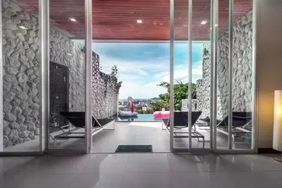 a living room with a large glass door with a view at Patong Villa1\u4e09\u5367\u6cf3\u6c60\u522b\u5885\u4e24\u4e2a\u6d77\u666f\u623f \u8fd1\u73ed\u8d5e\u6c5f\u897f\u51b7\u6d77\u6ee9\u4e2d\u6587\u7ba1\u5bb6 in Patong Beach