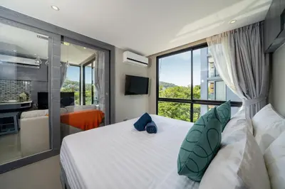 a bedroom with a large bed and a large window at Modern Tropical Kamala Beach in Phuket Town