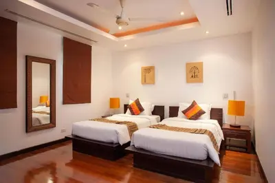 a bedroom with two beds and a mirror at The Residence Villa 203 in Bang Tao Beach
