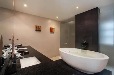a bathroom with a large white tub and a black counter at The Residence Villa 203 in Bang Tao Beach