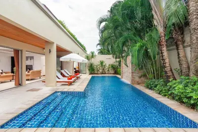 a swimming pool in the backyard of a house with palm trees at The Residence Villa 203 in Bang Tao Beach