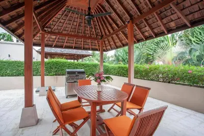 a patio with a table and chairs under a pavilion at The Residence Villa 203 in Bang Tao Beach