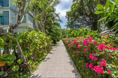 a walkway in a garden with pink flowers at 2 Bedroom Apartment in Naiyang - The Title Residences, Naiyang in Nai Yang Beach