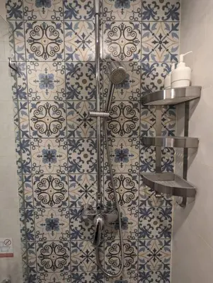 a shower in a bathroom with blue and white tiles at 2 Bedroom Apartment in Naiyang - The Title Residences, Naiyang in Nai Yang Beach