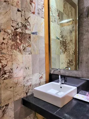 a bathroom with a white sink and a mirror at Blue Palm Kata Resort in Kata Beach