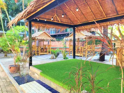 a pavilion with grass and plants in a restaurant at Blue Palm Kata Resort in Kata Beach
