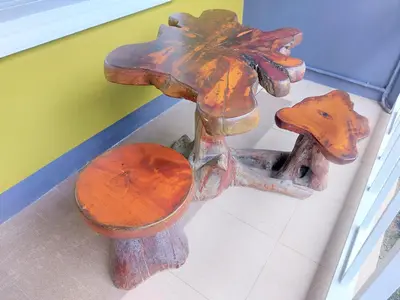 a wooden bench with a wooden mushroom on it at Blue Palm Kata Resort in Kata Beach