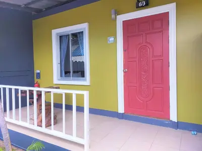 a red door on the side of a house at Blue Palm Kata Resort in Kata Beach