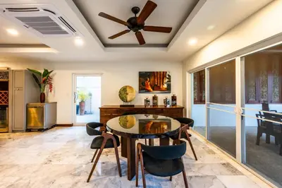 a dining room with a ceiling fan and a table and chairs at Kinnaree Grand Villa - pool, panoramic views, maid in Kamala Beach