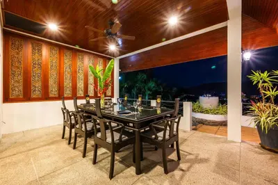 a dining room with a black table and chairs at Kinnaree Grand Villa - pool, panoramic views, maid in Kamala Beach