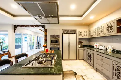 a kitchen with a stove and a counter top at Kinnaree Grand Villa - pool, panoramic views, maid in Kamala Beach