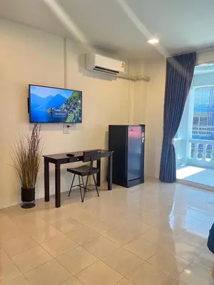 a room with a table and a tv on the wall at AB House in Kathu